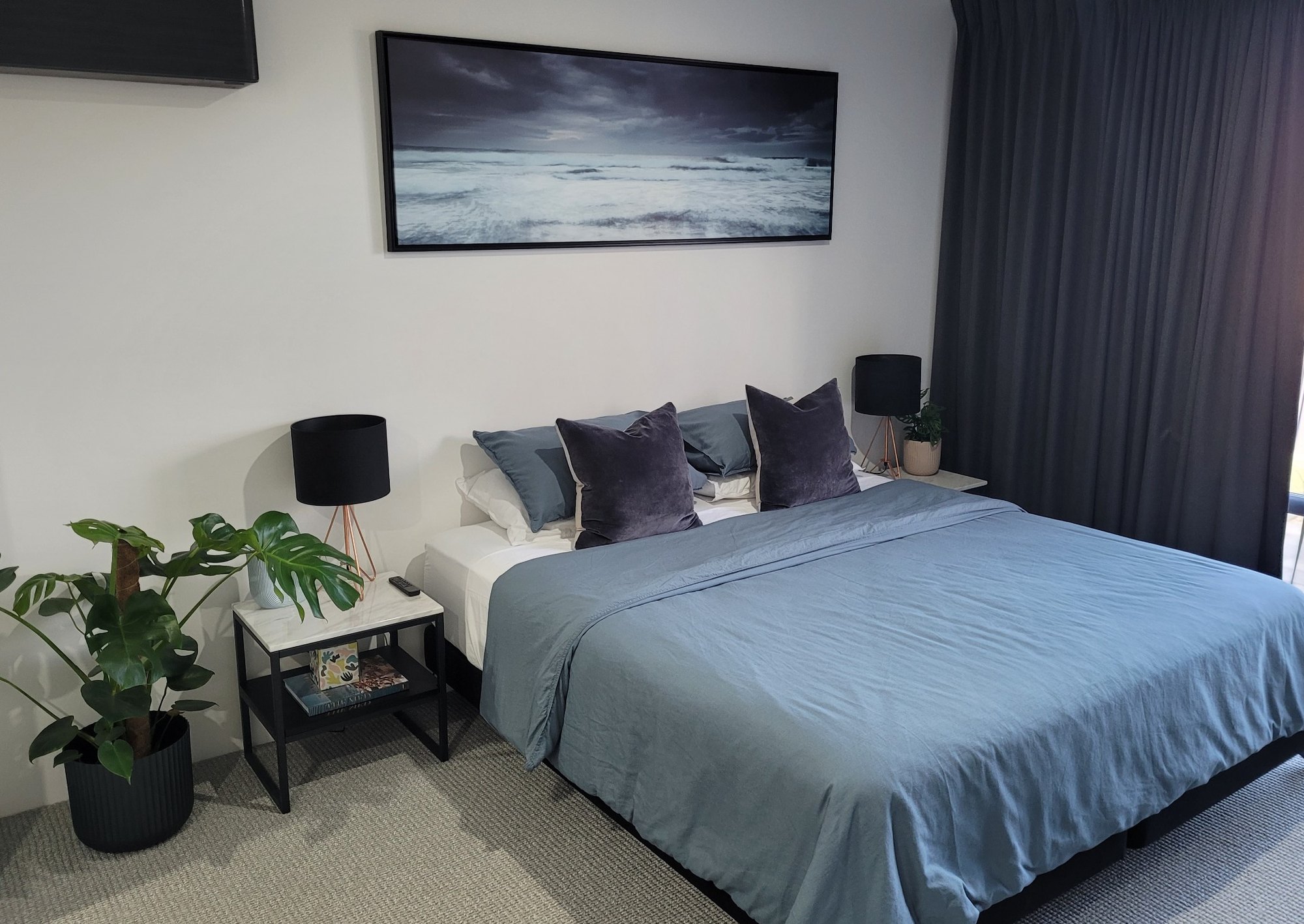 King bed with blue and charcoal linen in the BRiX suite